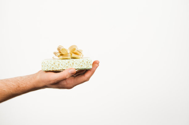 男人的手拿着礼品盒。双手赠送礼物孤立在白色背景。图片下载