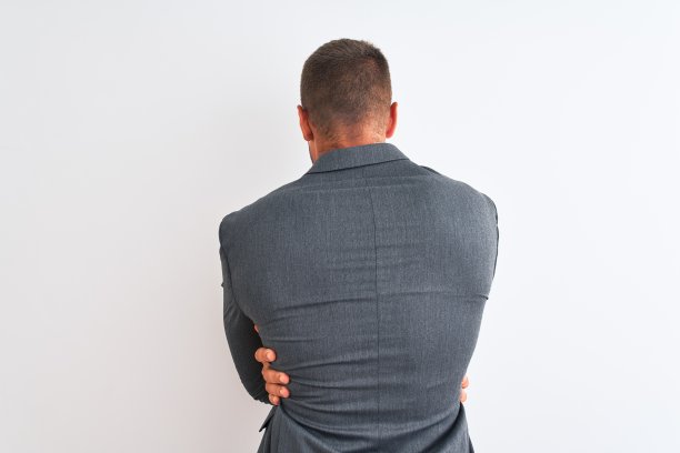 年轻英俊的商人穿着西装，打着领带，背景孤立，拥抱自己快乐和积极的背后。爱自己，关心自己图片下载