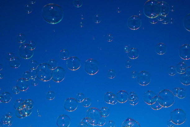 背景。各种大小的肥皂泡在蓝天上飞舞。图片下载