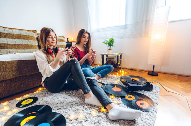 两个青少年使用手机听唱片图片下载