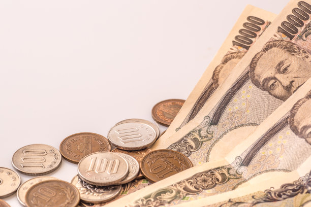 白色的桌子上放着日本的硬币、钞票和护照图片下载