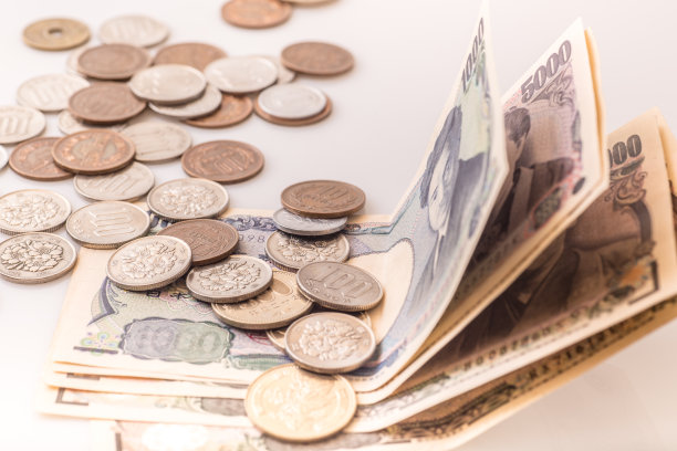 白色的桌子上放着日本的硬币、钞票和护照图片下载