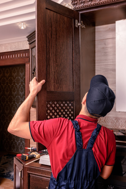 年轻工人在组装现代木制厨房家具图片下载