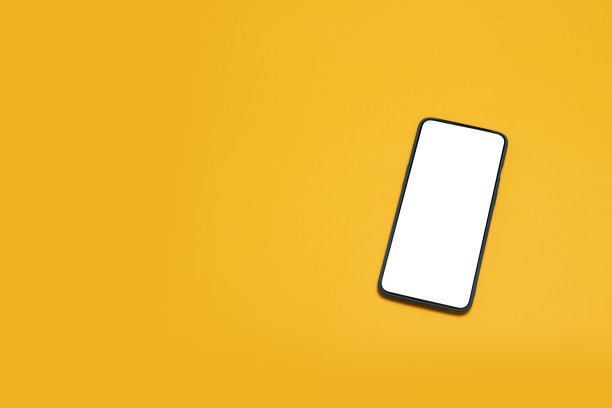桌面空白的智能手机。俯视图模型黑色智能手机在黄色背景图片下载