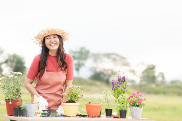 亚洲女人在花园里护理花卉。亚洲人在户外阳光明媚的环境中享受爱好和自由园艺图片下载