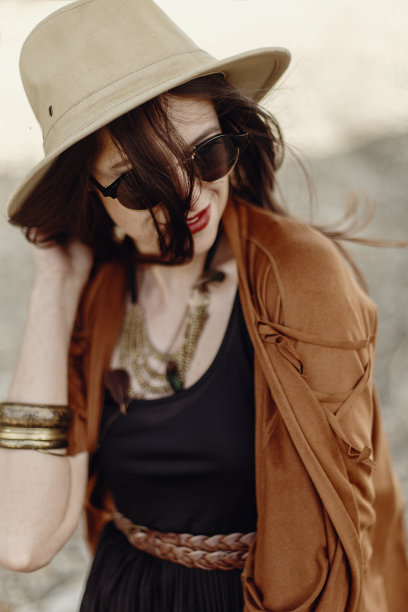 戴着太阳镜、拿着帽子、头发飘逸的时尚波西米亚风女人。吉普赛风格的时尚女孩，在山区河流海滩附近的年轻旅行者。夏季旅行。文本空间。图片下载