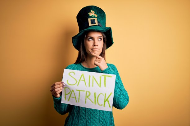 女子戴着绿帽子庆祝圣帕特里克节，举着旗帜与圣帕特里克短信严肃地面对思考问题，非常困惑的想法图片下载