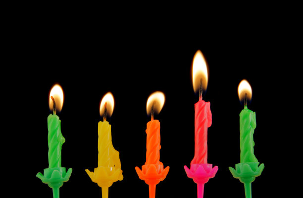 黑色背景上的彩色生日蜡烛图片下载