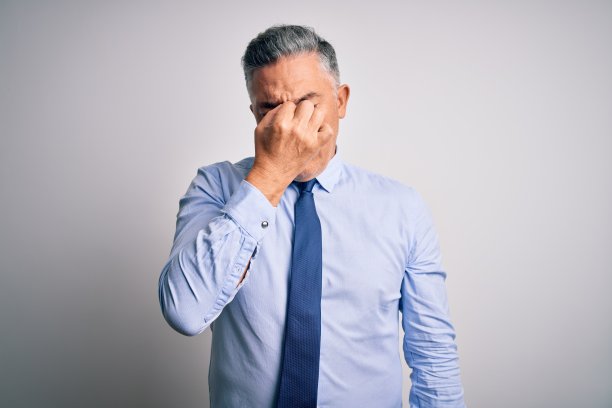 中年英俊灰发商人穿着优雅的衬衫和领带，疲倦地揉着鼻子和眼睛，感到疲劳和头痛。压力和沮丧的概念。图片下载