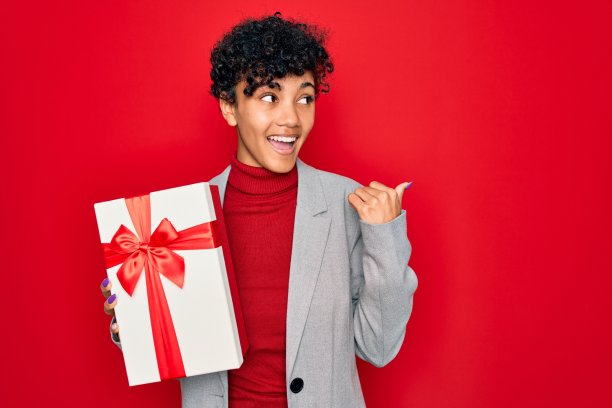 快乐的非洲裔女商人拿着礼物，指向一旁图片下载