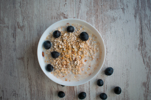 酸奶与格兰诺拉麦片和新鲜的蓝莓，在旧木背景玻璃碗图片下载