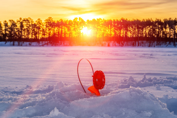 冬季日落时分，渔民们在河上的冰面上嬉戏图片下载