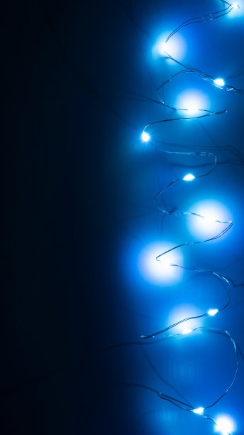 垂直顶视图的花环在黑暗的木制背景。蓝色灯光的圣诞背景，拷贝空间。图片下载