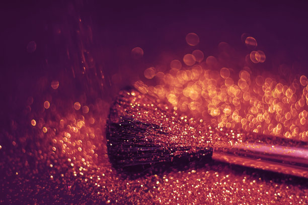 刷子和闪光粉的特写。非常浅的焦点在笔尖。指甲的质地闪闪发光。刷子旁边有一瓶指甲油。化妆品广告的概念图片下载