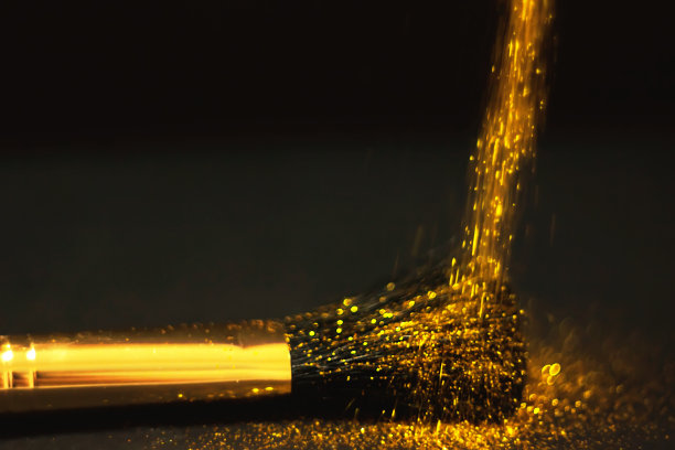 化妆刷和设计上的金色闪光纹理。在白色背景上。选择性聚焦-图像图片下载