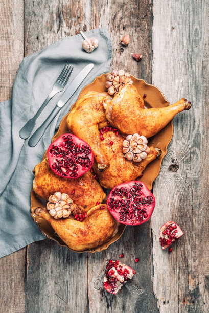 传统的感恩节庆祝派对。烤鸡配石榴和大蒜在木背景。朋友或家人聚餐。喜庆的圣诞餐桌。俯视图图片下载