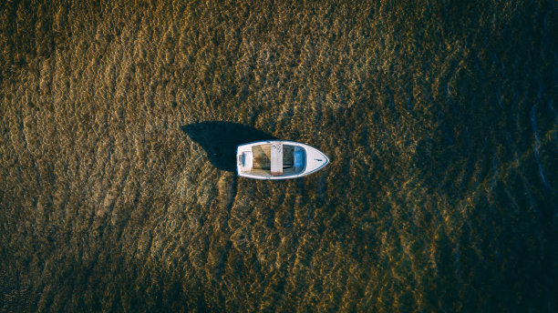 湖面上漂浮着一艘旧木船图片下载