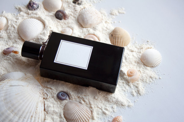 白色沙滩上的黑色香水瓶图片下载