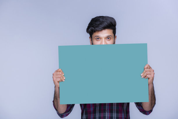 快乐的年轻人拿着一张绿色广告牌库存照片图片下载