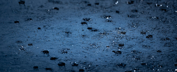 雨落在地面上，黑色的雨天气背景，水泡和水花在水面上，刷新自然上的水滴水模式，美丽的散水滴水图片下载