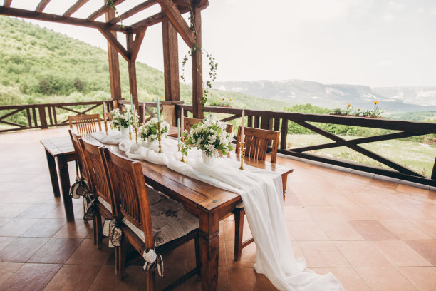 为新婚夫妇和客人装饰的餐桌与山景。婚礼装饰和花艺。图片下载