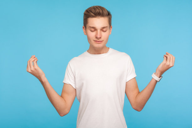 放松,心灵和谐。男人的肖像在休闲白色t恤抱着手臂在手印手势图片下载