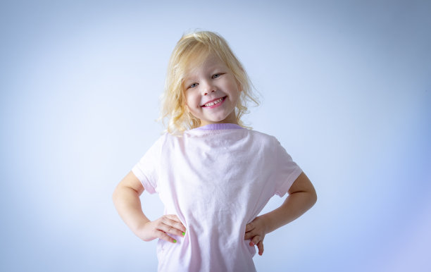 可爱快乐的宝宝无所畏惧地笑着，露出新牙，看着镜头，浅色背景图片下载