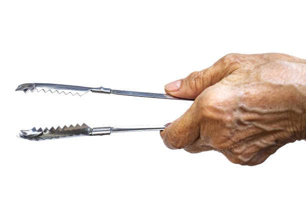 妇女左手拿着不锈钢钳子在白色背景上烹饪，近距离拍摄，选择性聚焦，厨房用具概念图片下载