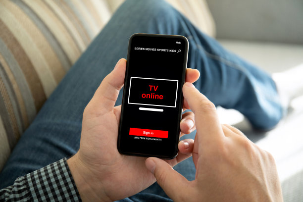 男性手持手机，屏幕上显示着在线电视应用程序图片下载