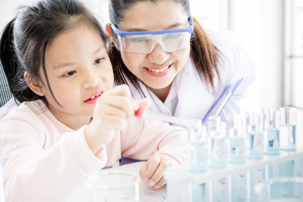 亚洲女教师指导小学生做化学实验特写，儿童科学教育图片下载