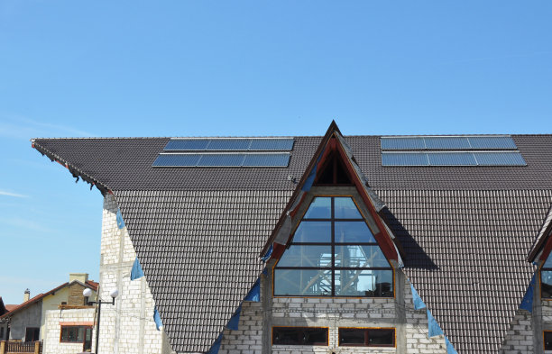 复杂的房屋建筑屋顶与太阳能热水器。图片下载