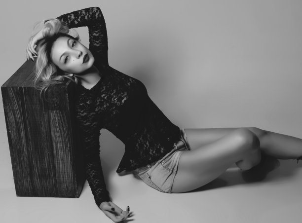 美丽的女人躺在木制的胸部，在白色的背景图片下载