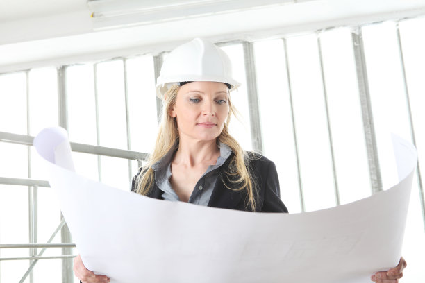 女建筑师或工程师在建筑工地看图纸图片下载