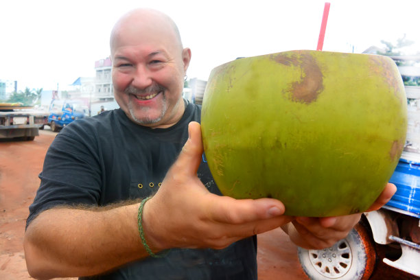 健壮的男人喝热带椰子图片下载