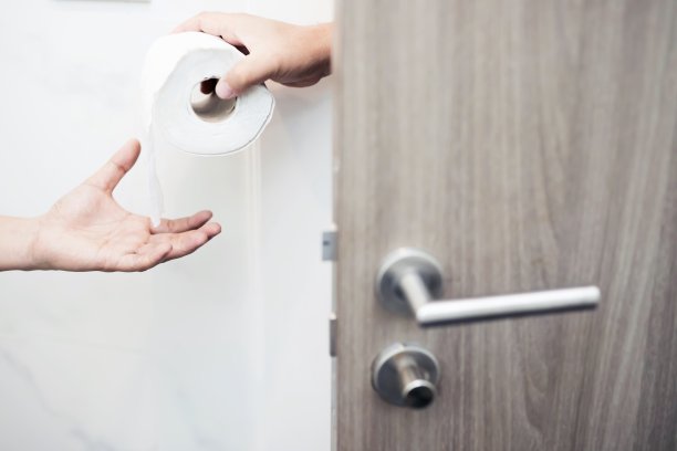 一个男人胃痛，在浴室里排尿。图片下载