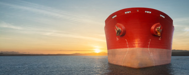 大红色商船在海上航行的特写镜头。负责货物进出口业务。图片下载