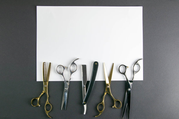 剪刀，理发器，梳子，危险的剃须刀在白色的床单上在黑色的背景。美容的概念图片下载