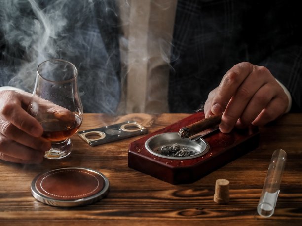 一个男人在酒吧里喝着威士忌，抽着雪茄图片下载