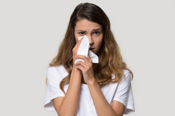 悲伤的年轻女人用纸巾擦眼泪图片下载