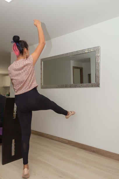 少女在家里摆芭蕾舞姿势，陪伴她的狗躺下图片下载