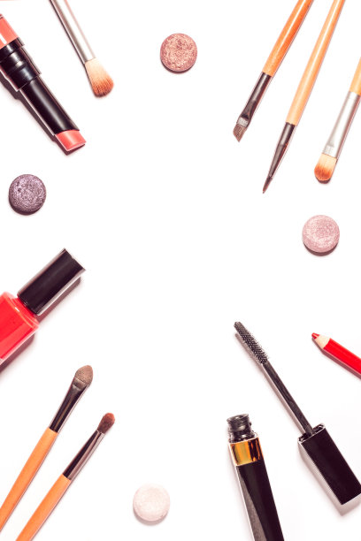 在白色的桌子上平铺着极简风格的化妆产品。框架黑色睫毛膏，口红，春季眼影调色板，不同的化妆刷。俯视图，复制空间。图片下载