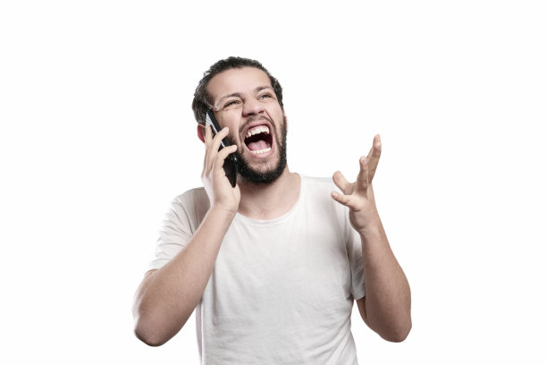 一名愤怒的年轻人在白色背景下使用智能手机图片下载