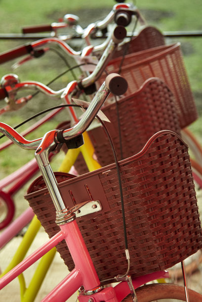粉红色的自行车和棕色的篮子排成一排。图片下载