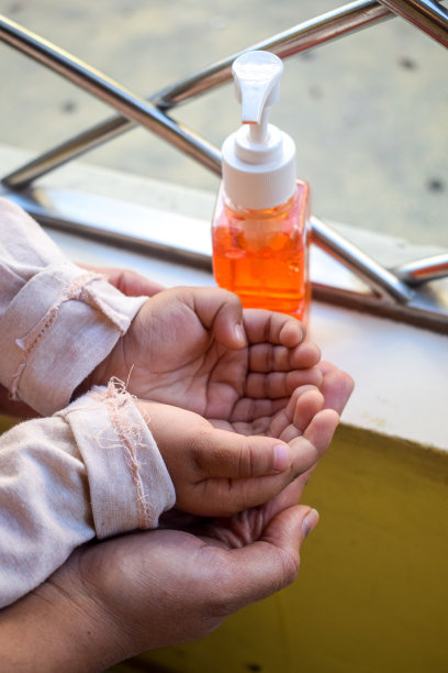 妈妈挤洗手液在她的小女儿的手上- stock照片，孩子的手使用洗手液洗手液。- - -库存图片图片下载