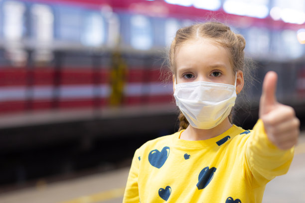 高兴、快乐、美丽快乐的孩子们戴着医疗保健护卫或保护口罩，穿着黄色t恤在地铁或地下大厅里图片下载