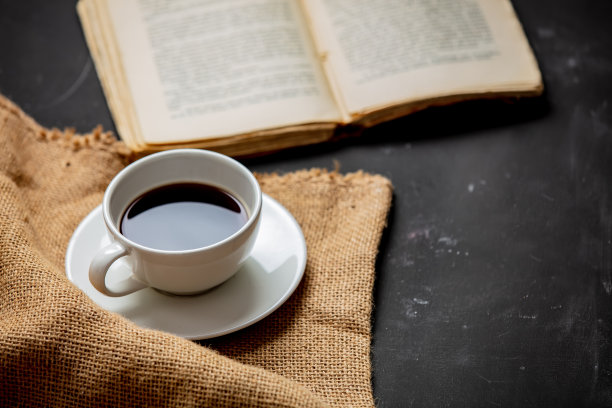 桌上放着一杯咖啡和一本古董书图片下载