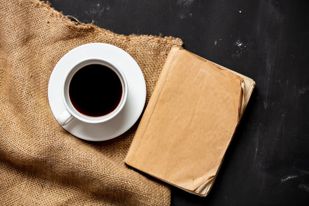 桌上放着一杯咖啡和一本古董书图片下载