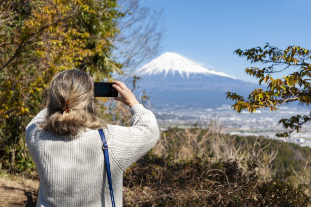 女人拍摄富士山及富士市鸟瞰图图片下载