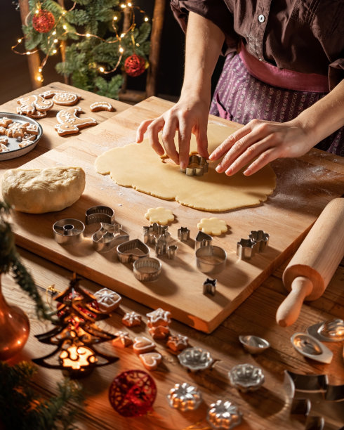 女人在擀开的面团上剪出形状准备林泽圣诞饼干图片下载