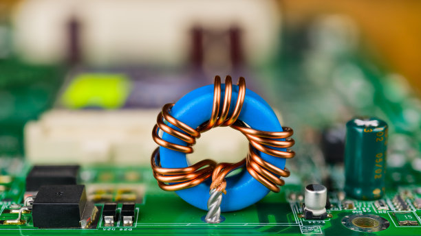 绿色电路板上的蓝色环形感应线圈。电脑主板的细节。电工学图片下载